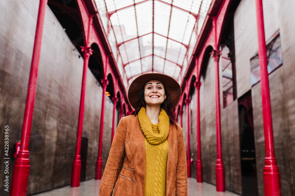 Fototapeta premium young caucasian woman outdoors over red columns building. Travel concept