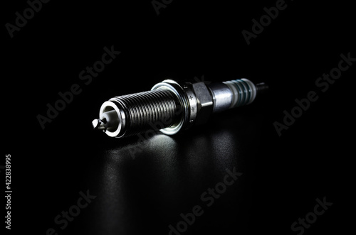 spark plugs for a car engine on a dark background