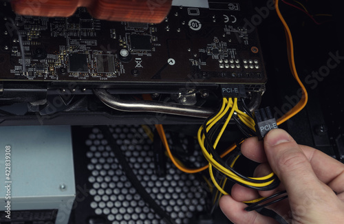 man is repairing a computer, replacing a video card