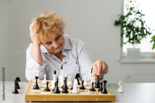 An old woman is playing chess