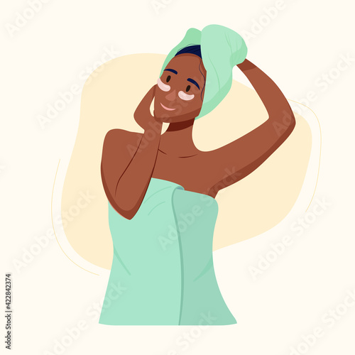 black girl cares for the skin. The girl in a towel on her head makes a facial massage.