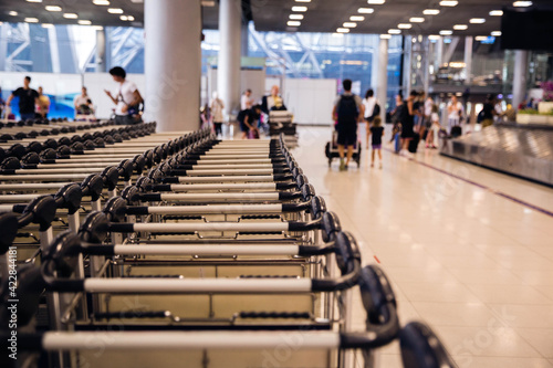 Close up photo of luggage trolley handles in a row in a modern airport.