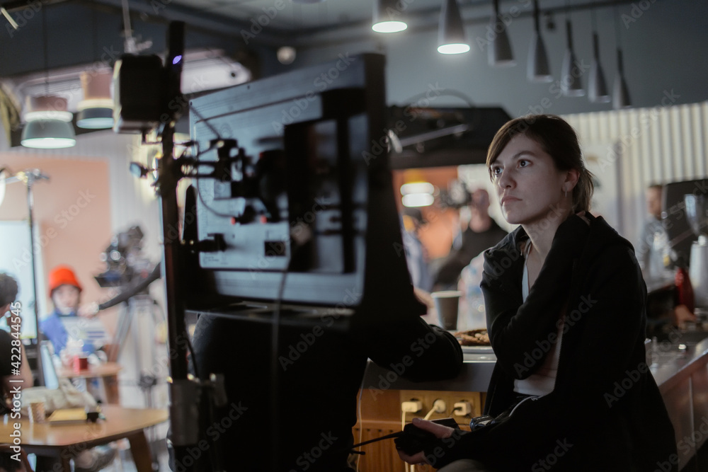 Director at work on the set. The director works with a group or with a playback while filming a movie Director at work on the set. The director works with a group or with a playback while filming a movie