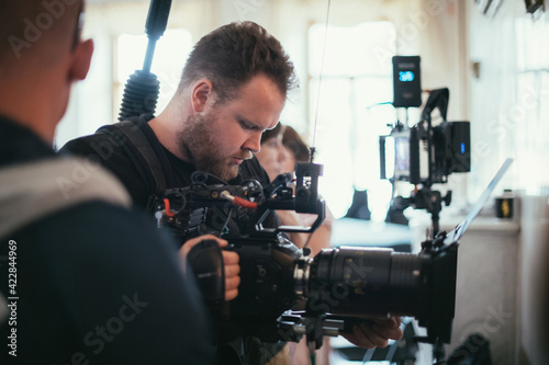 Director of photography with a camera in his hands on the set. Professional videographer at work on filming a movie © Anna