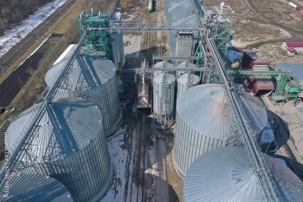 Grain elevator business with large storage bins of corn, grain, soybean. Agriculture, food, harvest, farm, farming, crops, auger, elevator, conveyor, ladder, silos, transport, company, rural, country
