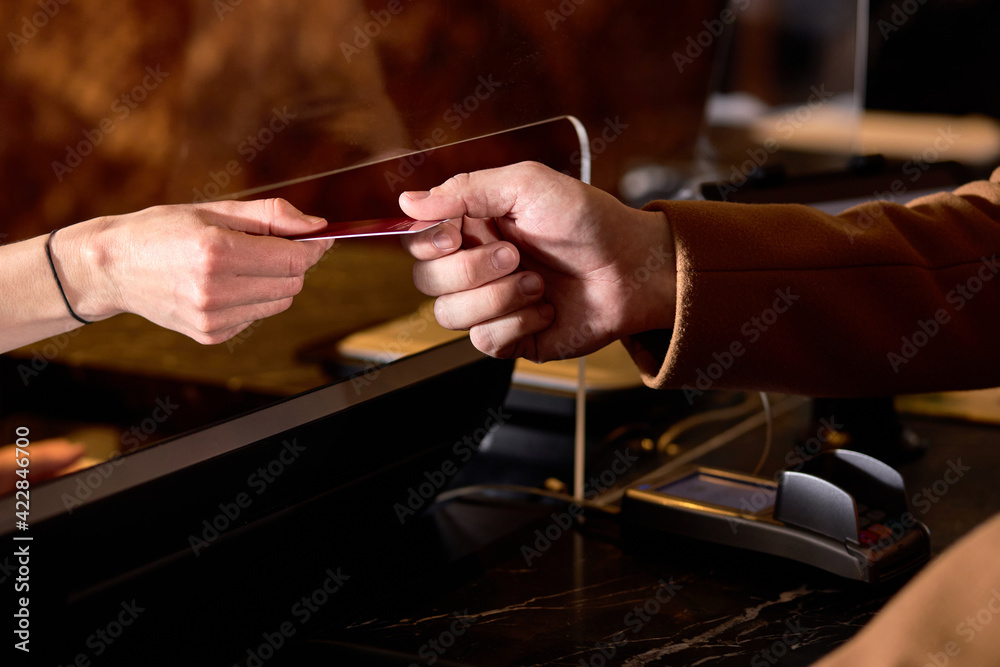 cropped man in Hotel check in at reception or front office being given key card close-up hands