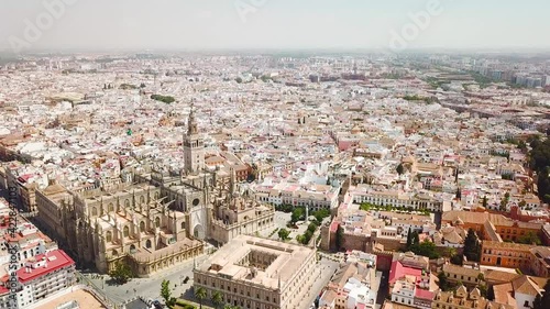 Drone point of view of Seville Cathedral, and city center. Famous travel destination in Spain. Empty street due to Corona Virus measures. Drone forward above the Triumfo Square. No tourists photo