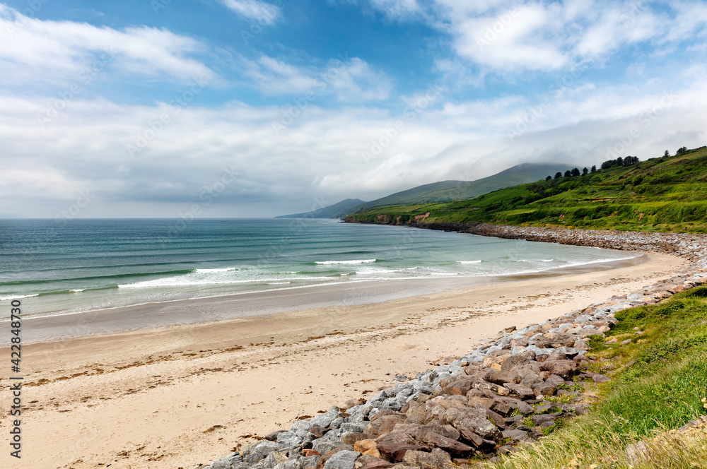 Natural beach of Ireland in the Atlantic Ocean with farm pastures and mountains Natural beach of Ireland in the Atlantic Ocean with farm pastures and mountains