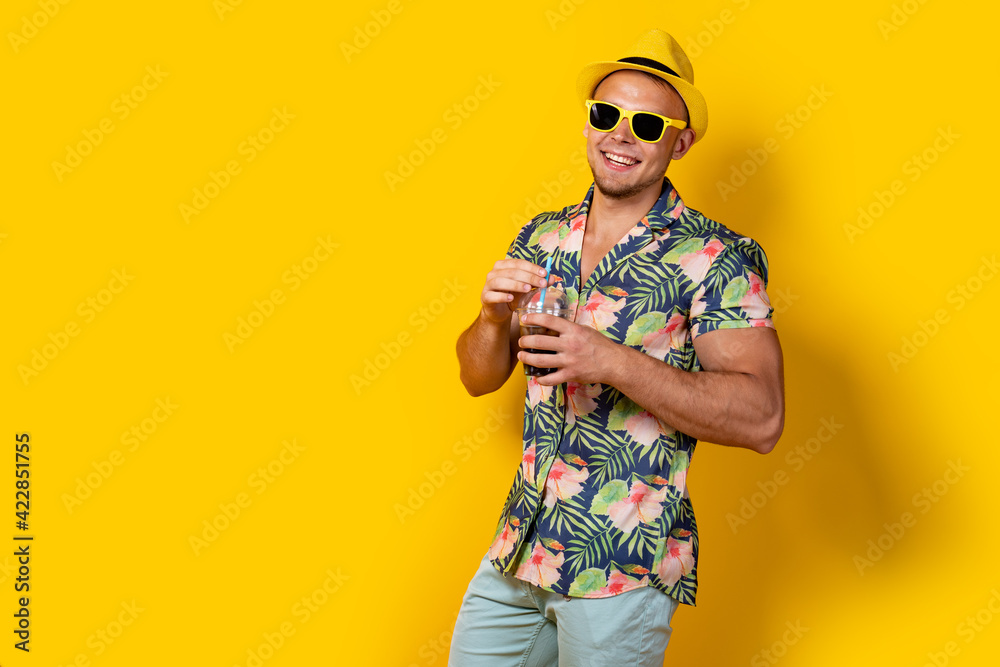 Man in bright clothes with beverage on yellow
