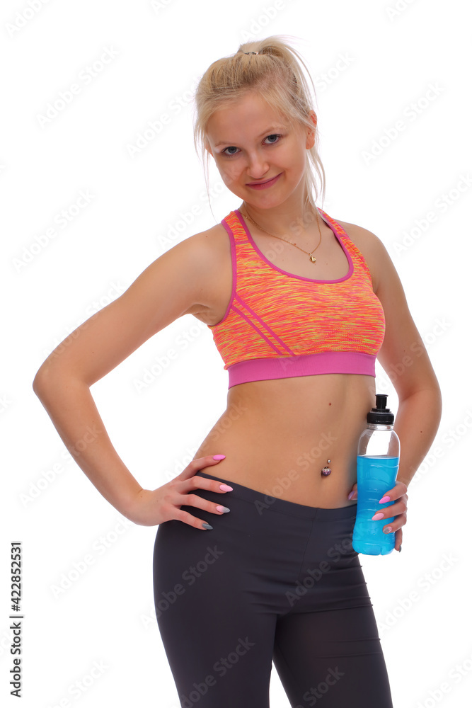 Smiling girl with fitness training holds bottle with energy drink in hand Smiling girl with fitness training holds bottle with energy drink in hand