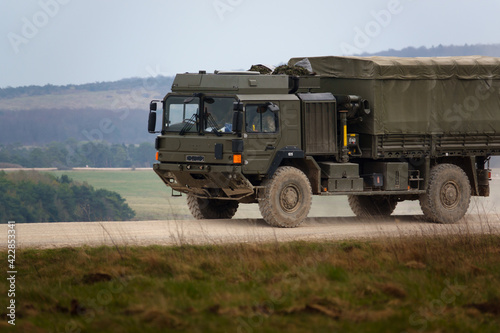 MAN SV 4x4 army logistics vehicle driving along a dusty stone track on a military battle exercise, Wiltshire UK