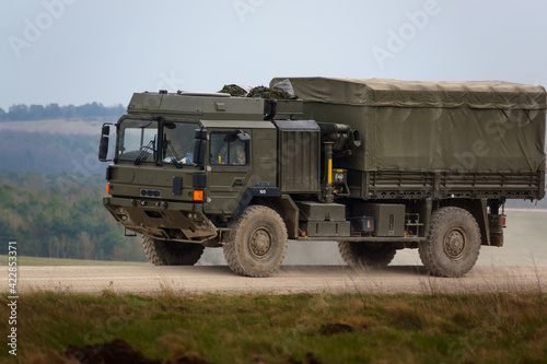 MAN SV 4x4 army logistics vehicle driving along a dusty stone and dirt track on maneuvers, Salisbury Plain Wiltshire