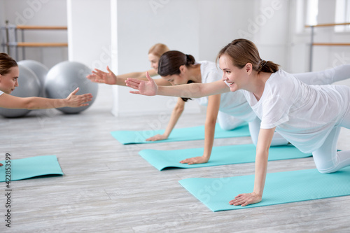 flexible hardy pregnant women exercising with fitness coach trainer