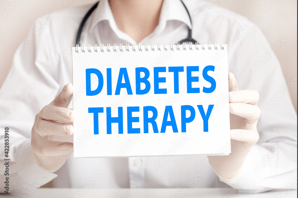 doctor holds a white sheet of paper and points to the text DIABETES THERAPY, medical concept doctor holds a white sheet of paper and points to the text DIABETES THERAPY, medical concept