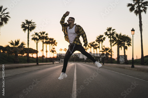 Young stylish European man jumping on the street