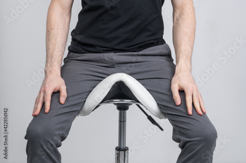 Canvastavla Young man sitting on a saddle chair.