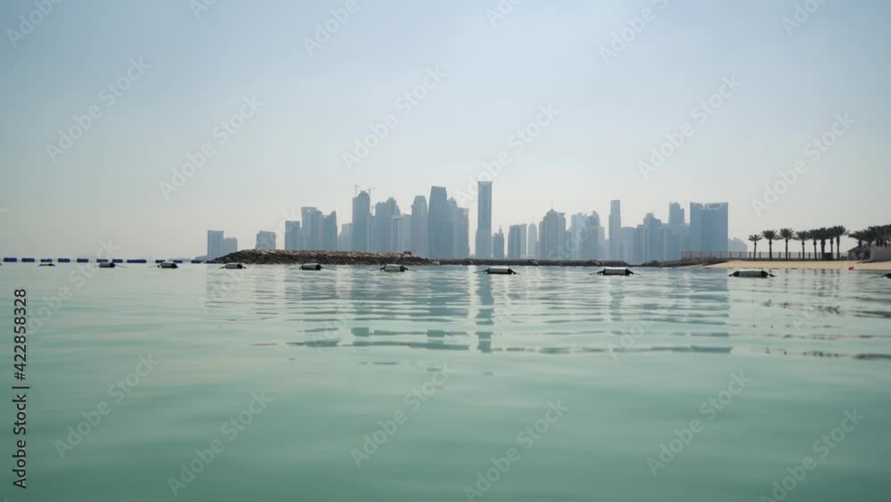 The Skyline of Doha, Qatar, from the sea, with reflections on the water The Skyline of Doha, Qatar, from the sea, with reflections on the water