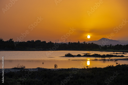 Sunset at the Larnaca salt lake witht he setting sun and wind turbines in the distance © Iordanis Pallikaras