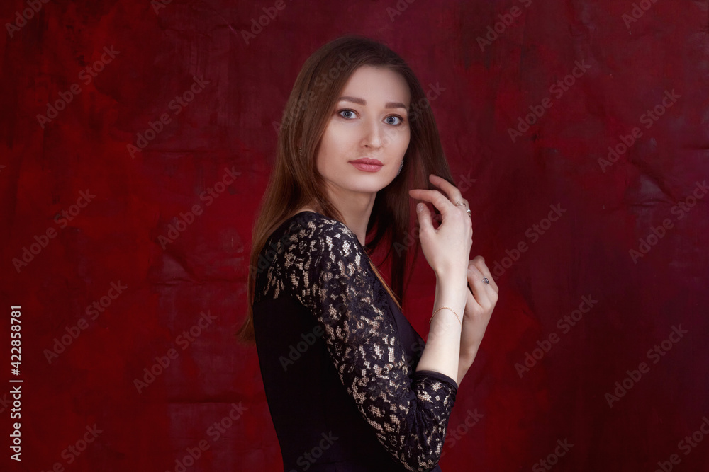 Portrait of a young woman with long brown hair, on a red textured background Portrait of a young woman with long brown hair, on a red textured background