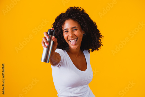 Beautiful African American girl wearing desororante, with afro hair and smile printed on her face and expression, deodorant spray, perfume