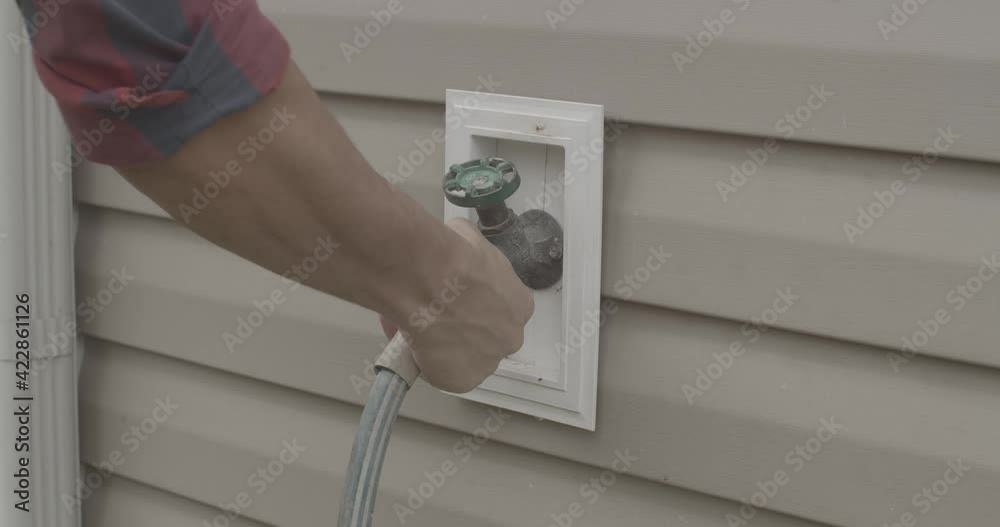 Male disconnecting an old garden hose from an outdoor faucet. Stock ビデオ