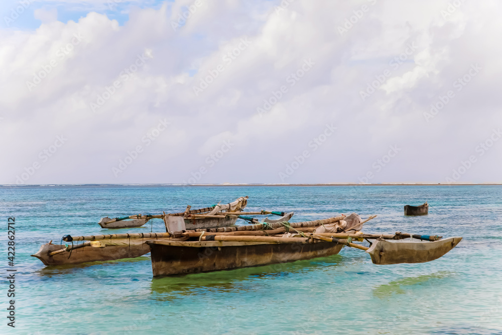 old handmade african  dhow fishing wooden boat anchored in the ocean in sunny weather