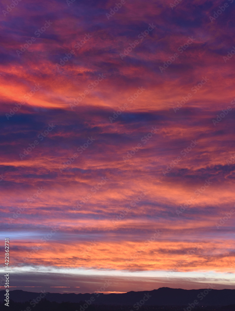 Epic scene of a cloudy sky during sunrise with purple and pink colors