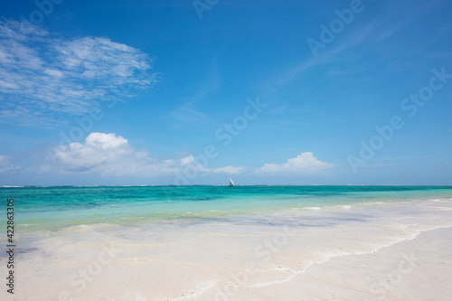 seascape, ocean shore, clouds and sun in the sky