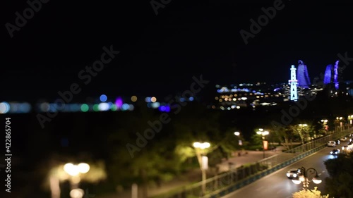 Tilt-shift unique aerial view of Neftchilar Avenue busy at night with cars with illuminated part of the city including Flame Towers, the trio of skyscrapers and cars driving fast
 photo