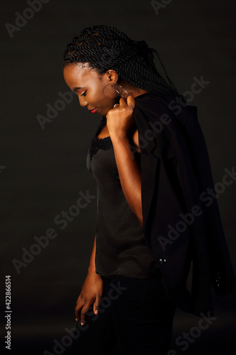 Black afro girl with dreads holding jacket  look down  profile view long dreadlocks  studio shoot  Spain  Vitoria- Gasteiz  March 2021