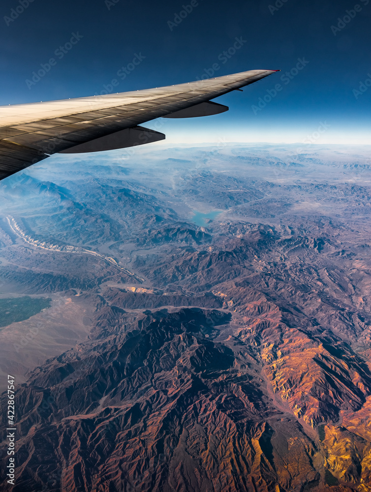Aerial View from an Airplane. Flying above Beautiful Land at Sunrise.