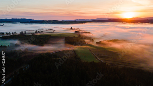 Aerial view of sunrise through the mountains. Drone photo of sunset in a forest. Landscape with fog. Galicia, Spain