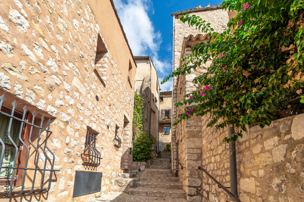 A narrow alley and staircase in a residential area of the medieval walled village of Tourrettes Sur Loup in the Alpes-Maritimes section of France.