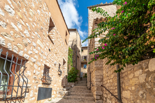 Fototapeta Naklejka Na Ścianę i Meble -  A narrow alley and staircase in a residential area of the medieval walled village of Tourrettes Sur Loup in the Alpes-Maritimes section of France.