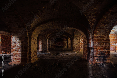 Dark and creepy vaulted red brick dungeon © Mulderphoto