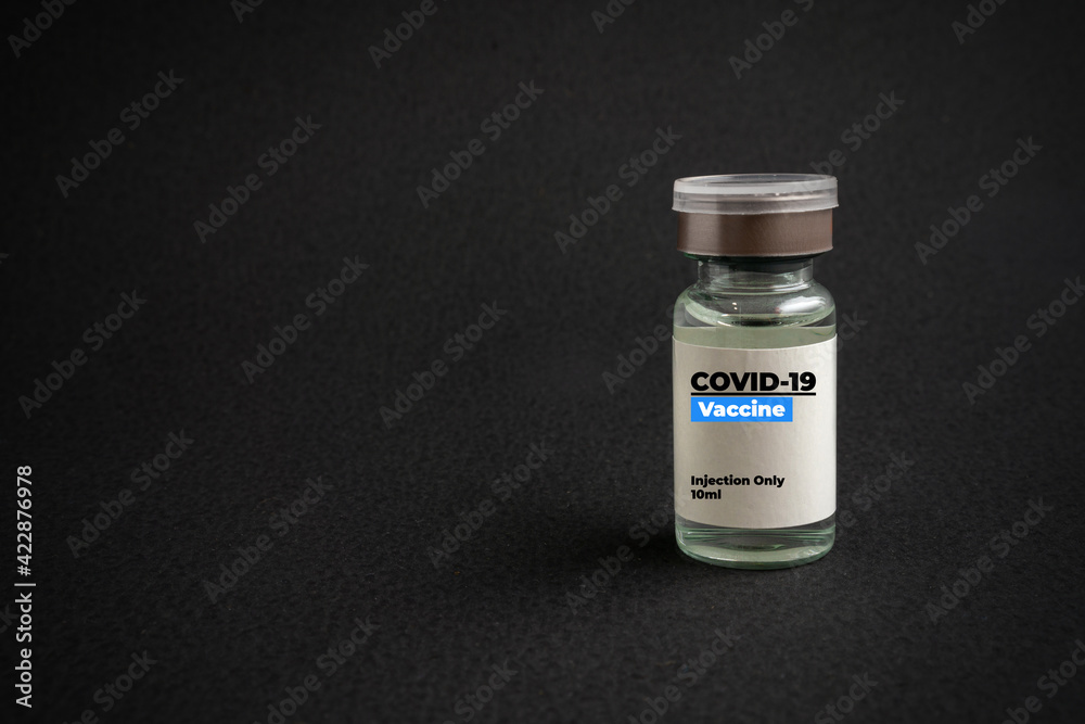 A bottle of vaccine on black background. Covid-19 or Coronavirus Concept. Copy space. A bottle of vaccine on black background. Covid-19 or Coronavirus Concept. Copy space.
