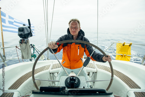 Skipper drives the sailboat in the Aegean sea. Yachting. Sailing.