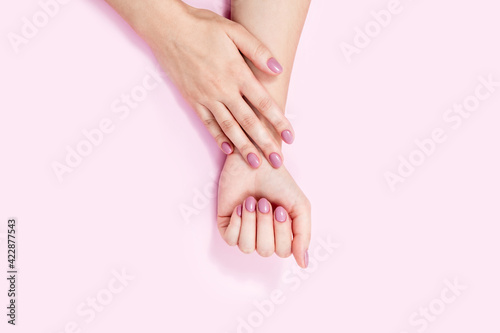 Beautiful female hands on a pink background. 