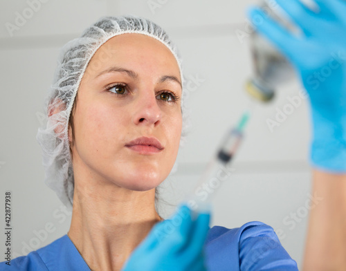 Positive nurse taking injection with a syringe