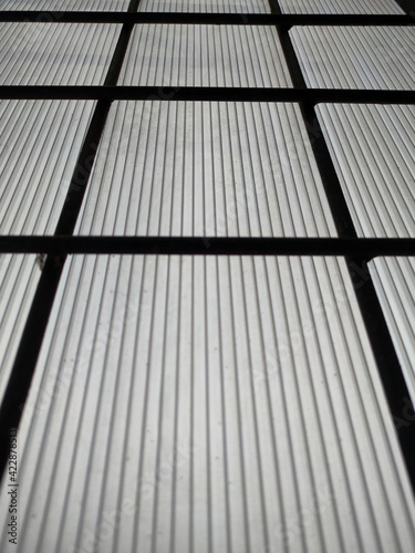 metal grid background and window light background from bed. Light from behind the iron bars of the window box. 