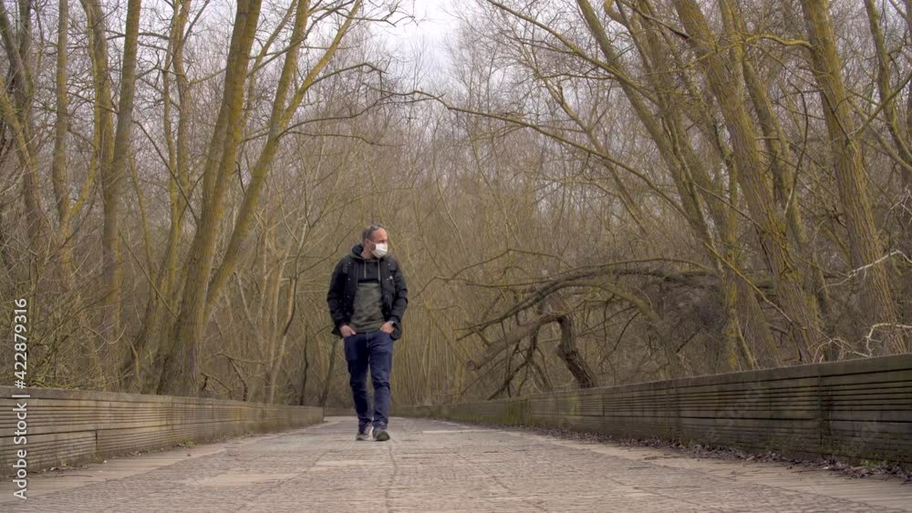 Lonely young adult Caucasian male student walking wearing face mask Lonely young adult Caucasian male student walking wearing face mask