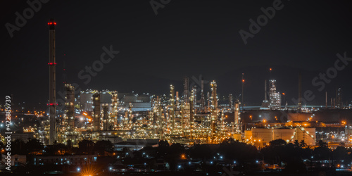 The aerial view of oil refinery factory and oil storage tank industry plant power at twilight and night sky background.