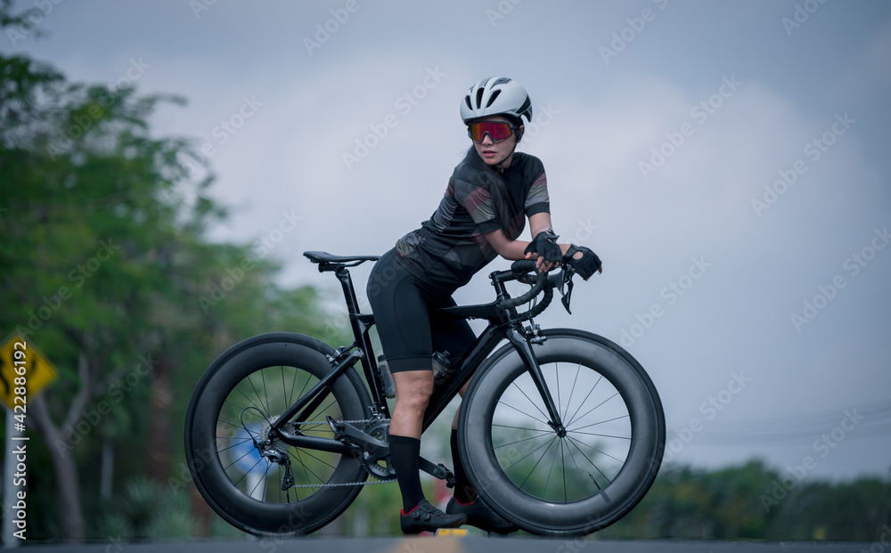 Beautiful biker wearing sport wear sunglass and helmet ride cyclist with her mountain bike in race adventure outdoor game competition on road, extreme healthy sport concept. Beautiful biker wearing sport wear sunglass and helmet ride cyclist with her mountain bike in race adventure outdoor game competition on road, extreme healthy sport concept.