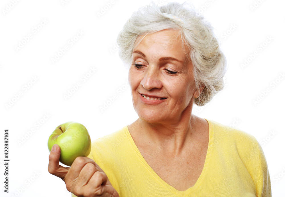 Mature smiling woman with green apple over white background Mature smiling woman with green apple over white background
