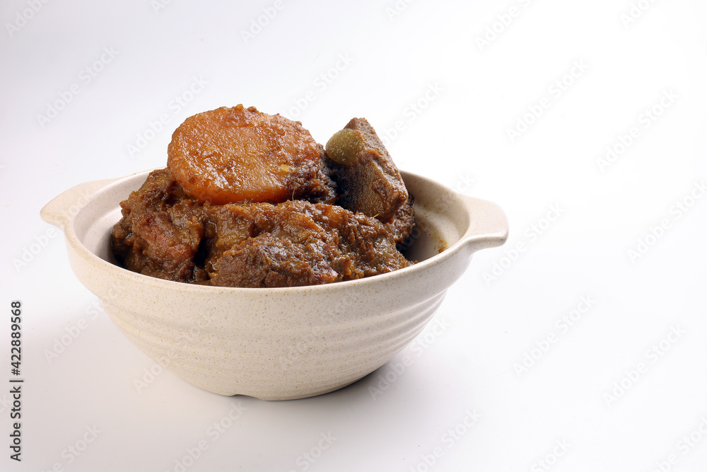 Asian style Beef bhuna dry curry with potato in ceramic bowl over white background Asian style Beef bhuna dry curry with potato in ceramic bowl over white background