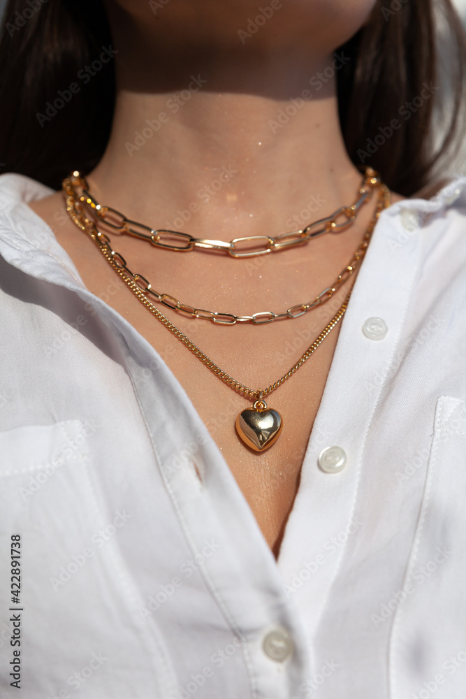 Beautiful model brunette in modern gold metal necklace chain Beautiful model brunette in modern gold metal necklace chain