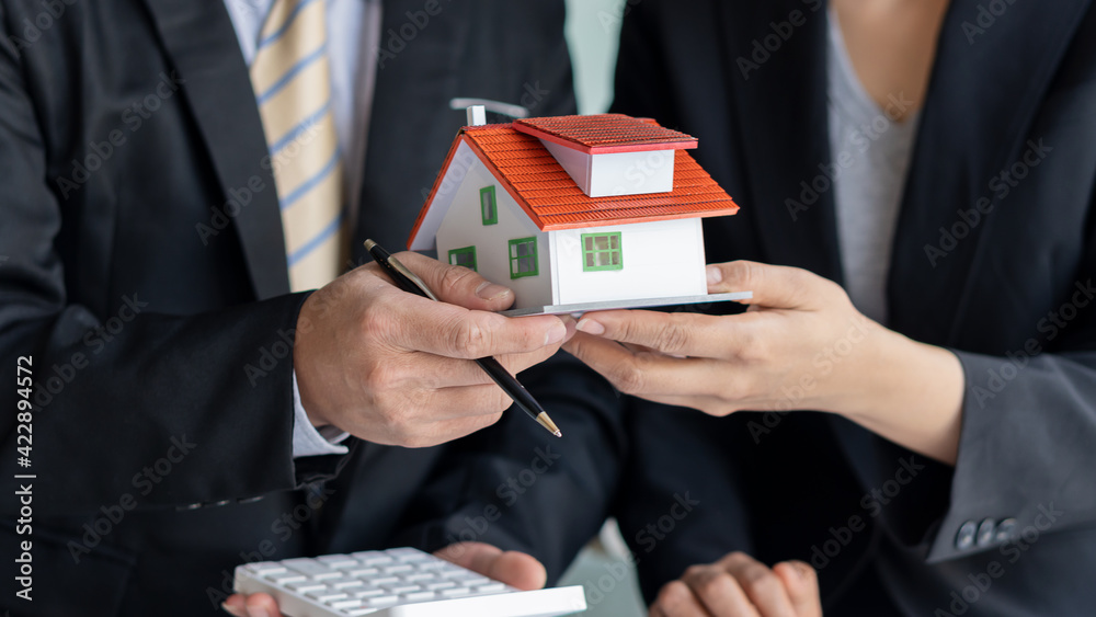 The broker delivers a small house design to the buyer after signing the purchase contract. Real estate trading ideas in the office The broker delivers a small house design to the buyer after signing the purchase contract. Real estate trading ideas in the office