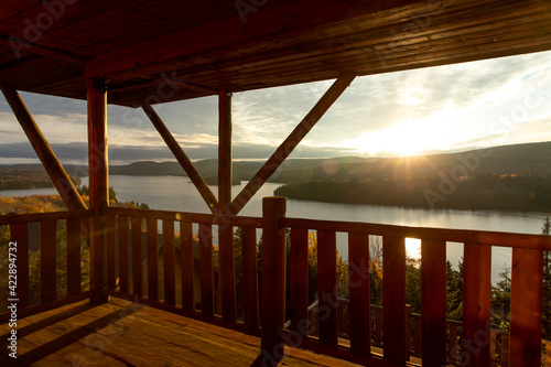 Coucher de soleil chaleureux avec un lac avec des iles montagneuses vue d'un balcon © Veronique