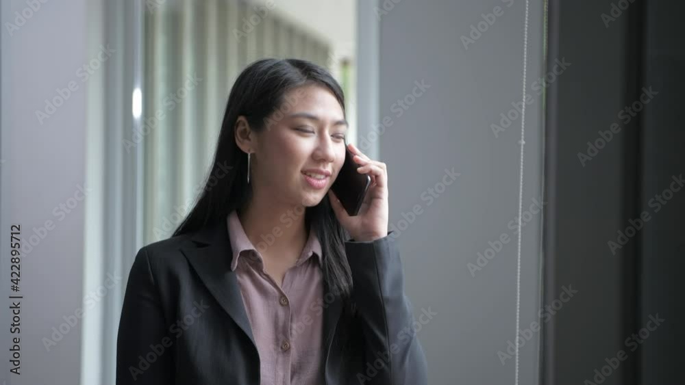 Business concept of 4k Resolution. Asian girls are happily talking on the phone in the office. Business concept of 4k Resolution. Asian girls are happily talking on the phone in the office.