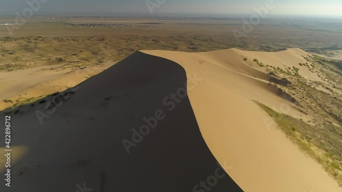 Fast motion aerial backwards grand  Sarykum Dagestan desert highest sandy yellow dune. Amazing wilderness on plain. Best nature Caucasus landmark Open space, horizon. Russia. Summer sunny travel film